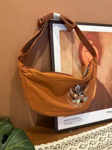 Detailed view of the stylish embroidered crescent crossbody bag with adjustable strap.