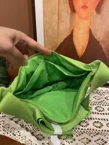 Detail view of the green nylon dumpling bag interior showing pockets and zipper storage.