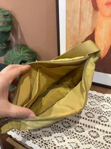 Nylon dumpling crossbody bag interior detail showing inner pockets and soft fabric lining.