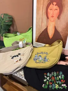 Detailed view of casual nylon crossbody dumpling bags featuring cute embroidered animal and floral designs.