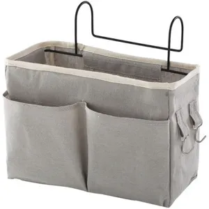 Detalle de bolsa de almacenamiento colgante gris, organizador de lona con bolsillos y ganchos.