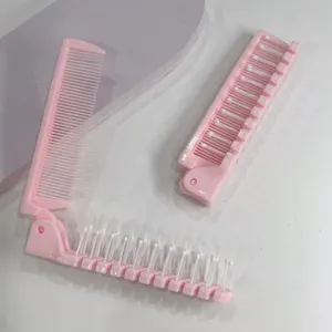 Vue détaillée du peigne double pliable portable en rose, montrant dents fines et picots de massage.