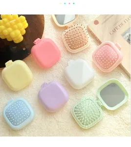Primer plano de bonitos cepillos de pelo plegables pastel con espejo, multicolor.