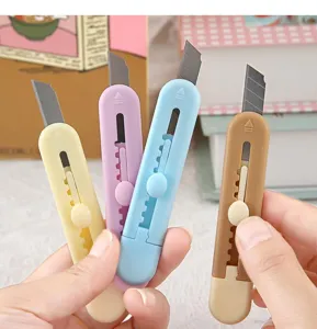 Primo piano dettagliato di simpatici cutter pastello con mini design retrattile per taglio.