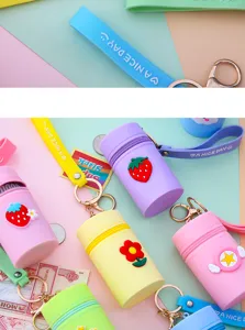 Silicone mini bucket bag coin purse keychain detail view with cute cartoon charms and straps.