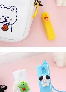 Dettaglio del mini flacone spray portatile con ciondolo a cartone animato e corda da appendere.