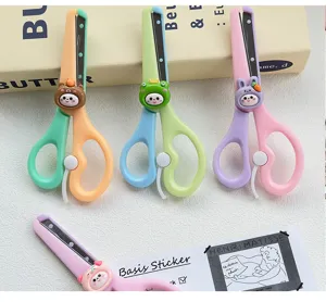 Closeup of colorful children safety scissors featuring cute animal designs like bear and bunny.