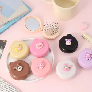 Vue détaillée d'une brosse à cheveux pliante mignonne avec miroir et design de dessin animé.