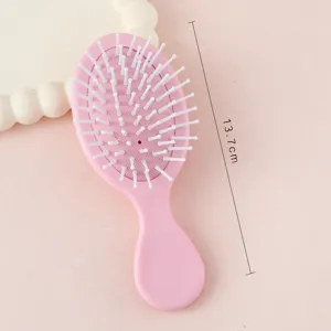 Mini brosse à cheveux rose avec picots blancs, peigne de massage portable pour enfants et femmes.