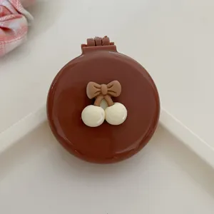 Portable foldable air cushion hair comb with cute bow and mirror for daily travel use.