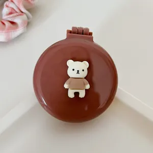 Portable folding air cushion hair brush with cute bear design and built-in mirror for daily use.