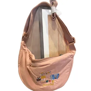 Pink nylon crescent crossbody bag with cute cartoon embroidery, adjustable strap, casual.