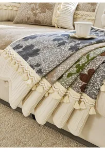 Vue détaillée d'une housse de canapé en chenille européenne avec pompons, charmant décor.