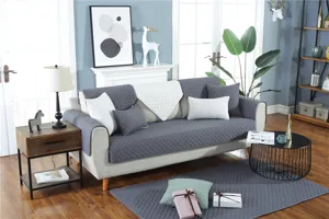 Quilted sofa cover detail shot showcasing modern gray and white fabric in living room.