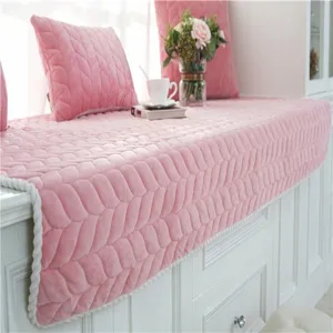 Detalle de cojín para ventana de terciopelo rosa con patrón acolchado en dormitorio