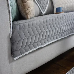 Kuscheliges Sofakissen Detail mit weicher Wintertextur und dekorativer weißer Randverzierung.