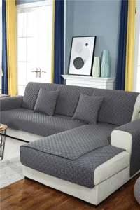 Detail shot of dark grey quilted sofa cushion cover with geometric texture in cozy living room set.