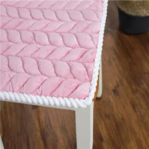 Nahaufnahme der Textur eines weichen rosa Plüsch-Stuhlkissens mit weiß geflochtener Kante.