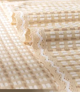 Fodera per divano in cotone minimalista con motivo a quadri e delicato bordo in pizzo.