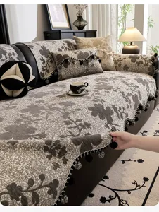 Close-up detail of vintage chenille sofa cover texture, elegant fringe ball trim and floral pattern.