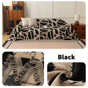 Funda de sofa de chenilla con patron geometrico en blanco y negro, detalles de flecos.