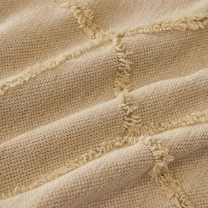 Close-up of beige chenille sofa throw blanket fabric showcasing soft tufted lattice pattern