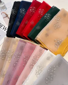 Detailed view of colorful polyester long scarves with pearl and rhinestone floral details.