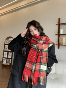 Cozy red plaid winter scarf detail shot, thick warm fringed design for women and men.