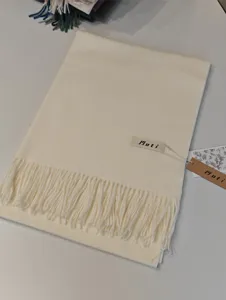 Detailaufnahme eines einfarbigen Kaschmir-Imitat-Schals mit Fransen für den Winter.