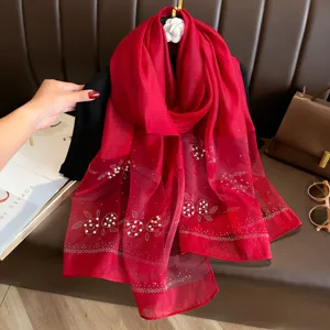 Red organza scarf detail, featuring delicate pearl and rhinestone beadings, elegant style.