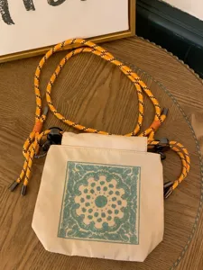 Beige drawstring shoulder bag with blue embroidery and orange rope strap for women fashion.