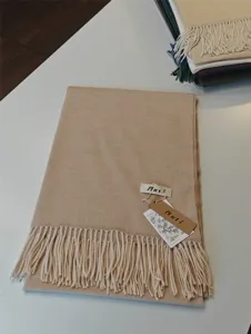 Detailansicht des einfarbigen Kunstkaschmir-Winterschals mit eleganten Fransen und Etikett.