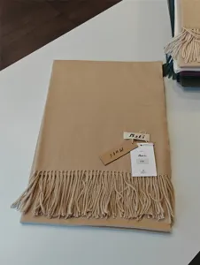 Nahaufnahme eines weichen Kaschmir-Gefühl Winterschals mit Fransen und Markenschild.