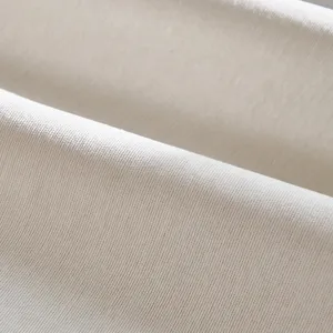 Tessuto per copridivano in ciniglia crema primo piano che mostra una consistenza morbida.