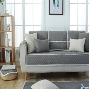 Modern quilted linen sofa cover set in grey color, minimalist furniture protector pad for living room.