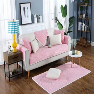 Detailansicht des kuscheligen rosa-weißen gesteppten Sofabezugs-Sets im gemütlichen Wohnzimmer.