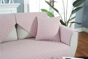 Pink quilted sofa cover detail showing soft fabric texture and elegant geometric pattern.