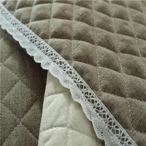 Quilted sofa cushion detail, textured brown fabric, white lace trim, non-slip backing.
