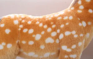 Close-upweergave van de schattige sika hert knuffel met zachte stoftextuur en gevlekt patroon.