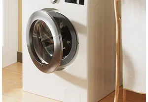 Lavatrice a carica frontale moderna di colore bianco con oblo argentato per la casa.