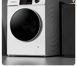 Close up view of the modern front load washing machine with sleek black door and white body.
