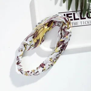 Detailed close-up of vintage floral print silk hair band, elegant accessory for wear.