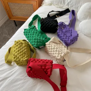 Detailed view of colorful knitted pop-corn crossbody bags in various trendy candy colors.