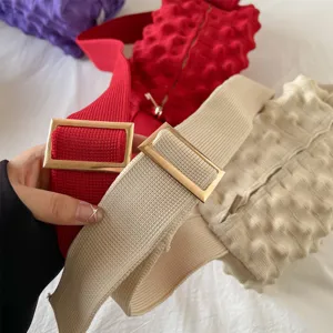 Knitted pineapple crossbody bag detail showcasing soft textured fabric and elegant metal buckle.