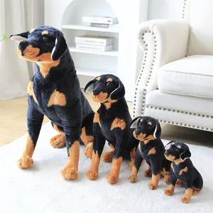 Detailed view of cute Rottweiler plush toy set featuring four sizes arranged in a cozy setting.