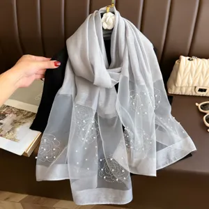 Écharpe en soie grise élégante avec perles et motif floral en strass brillant.