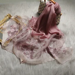 Detailed view of pink floral embroidered silk blend scarf, elegant shawl fabric texture.