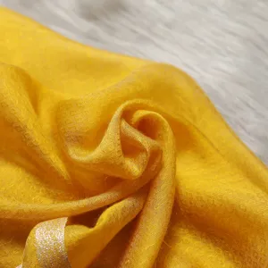 Close-up yellow silk wool blend scarf with delicate pattern, elegant and soft for women.