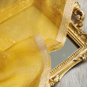 Detailed close-up view of elegant yellow sheer scarf featuring shimmering metallic edges.