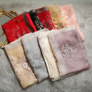 Close-up of colorful embroidered silk scarves and shawls with elegant floral patterns.